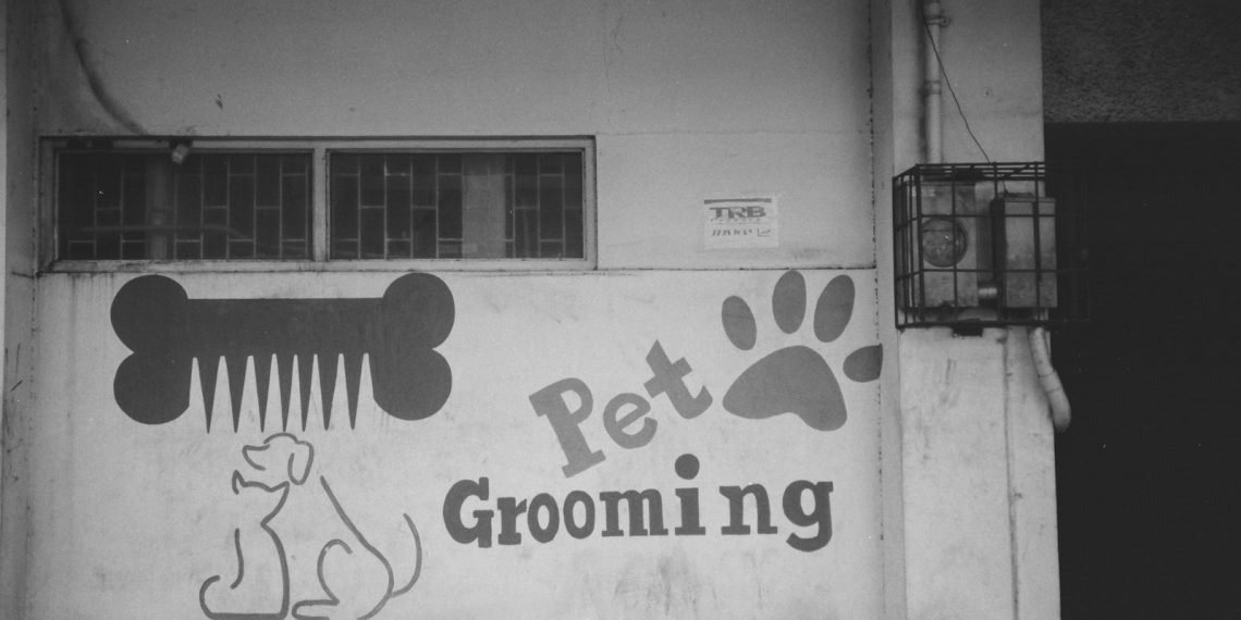 a black and white photo of a pet grooming sign
